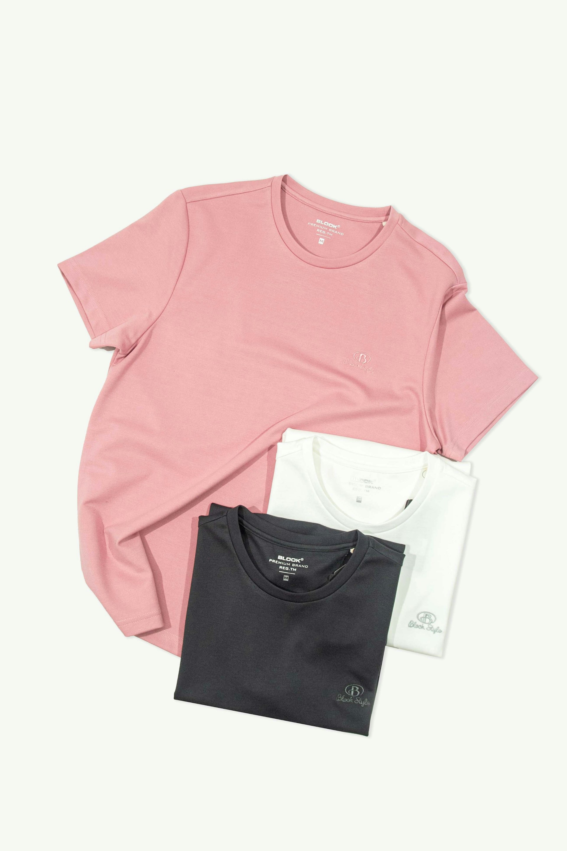 Neatly folded t-shirts in pink, white, and black colors